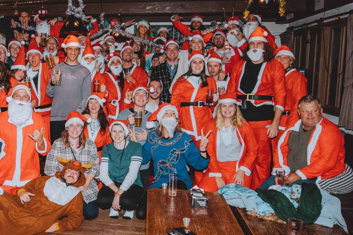 Large group in Santa costumes celebrating Santa Ski Day at a bar in Hakuba, Japan