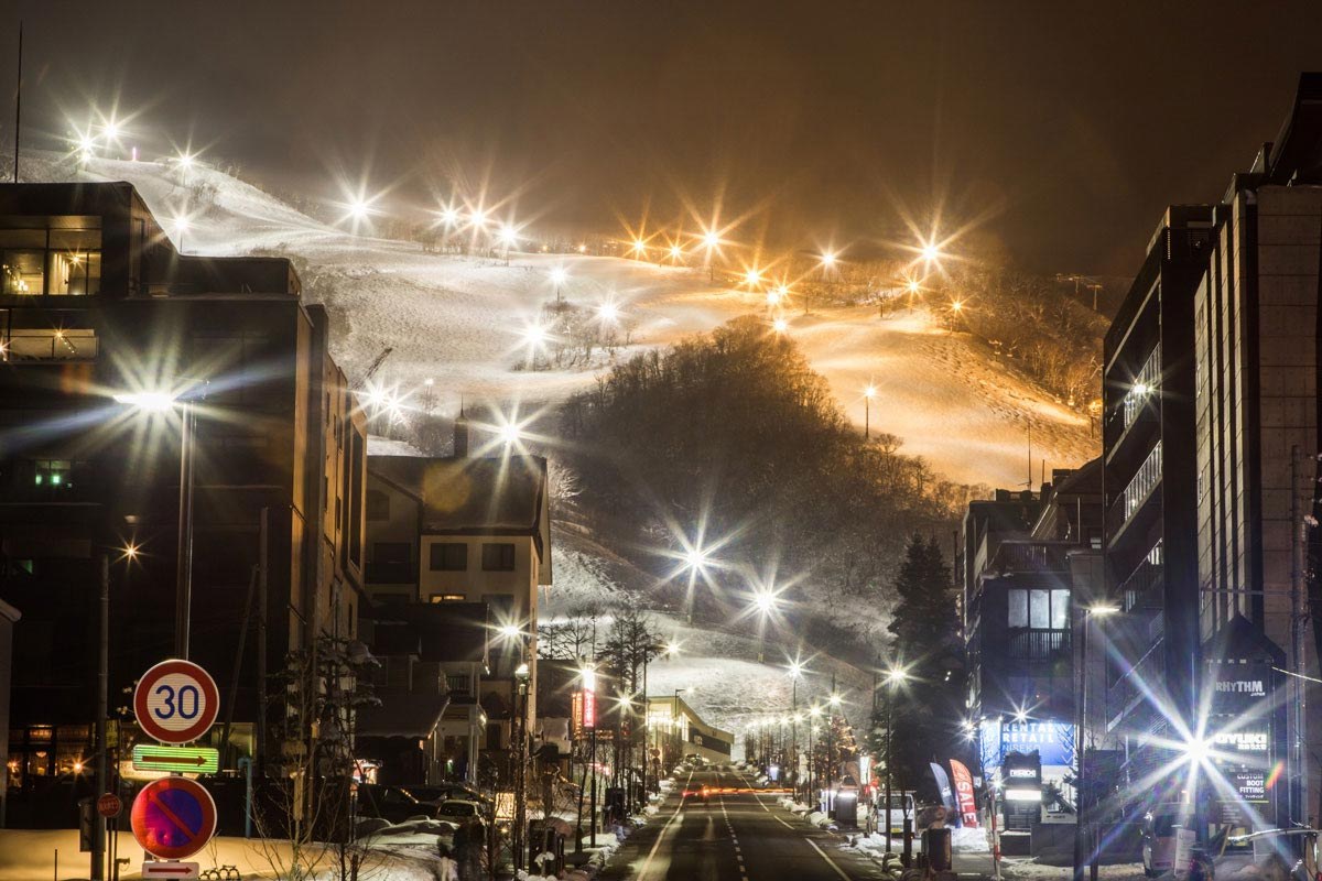 Illuminated ski slopes above Niseko village at night, Japan