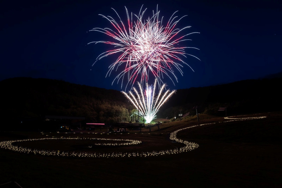 New Year's Eve fireworks over a torchlit ski run at Niseko, Japan