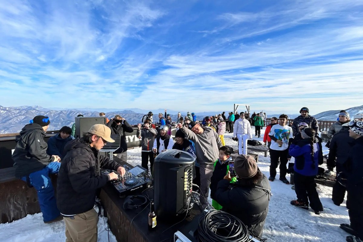 DJ performing at Oakley Terrace, with mountain views and a crowd of skiers at Hakuba