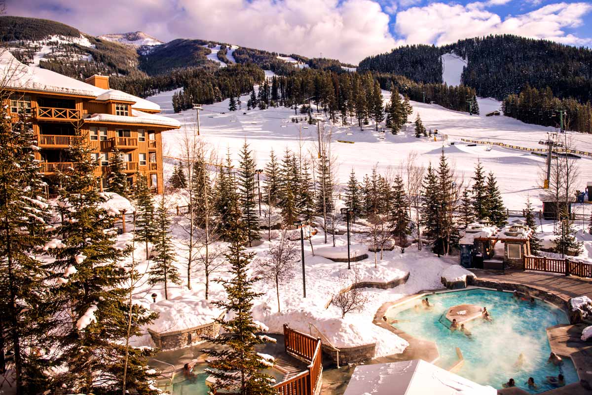 Slopeside hot pools at Panorama Mountain Resort with ski runs visible in the background
