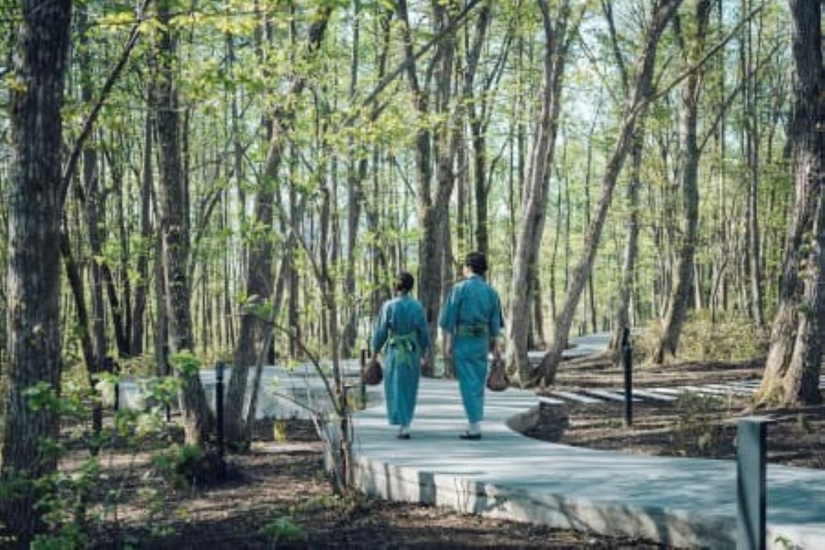 Guests in yukata walking the forest path to KAI Kusatsu's private tunnel